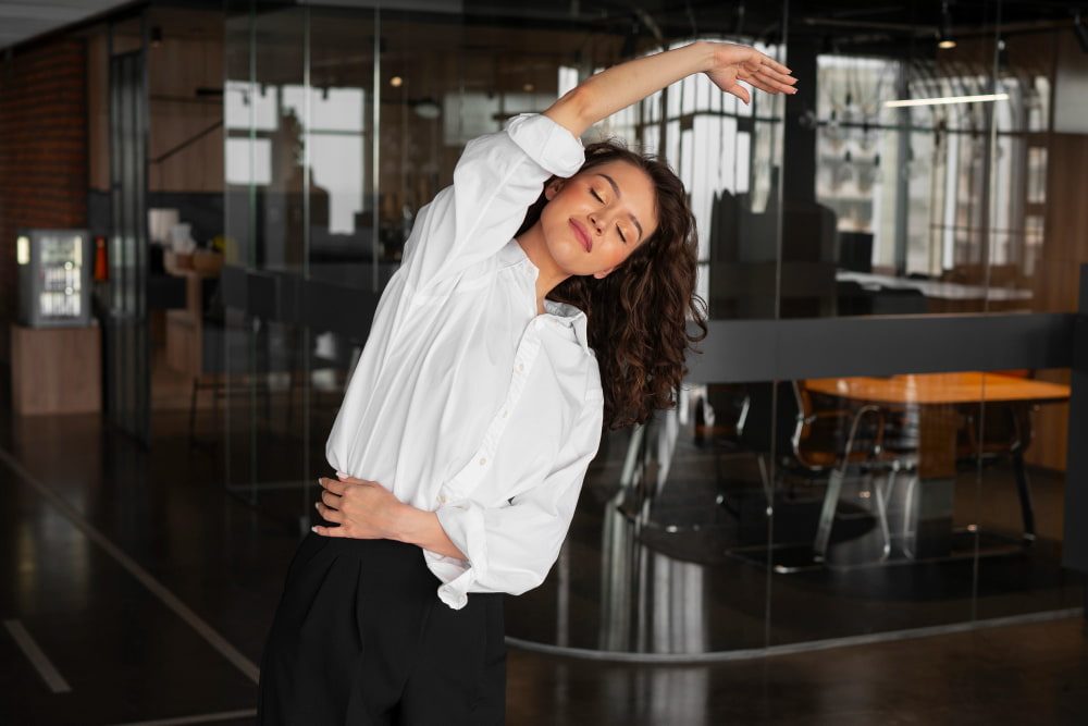 Une femme pratique du pilates au bureau